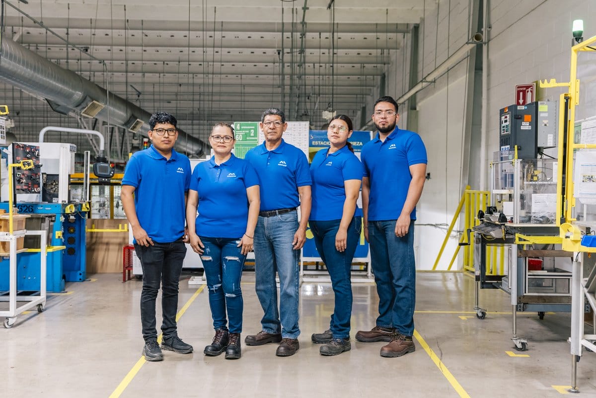 Five Tetakawi team members stand together on a Manufacturing Campus production floor in Sonora, Mexico | Tetakawi