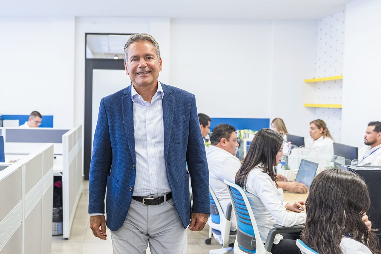 Carlos Martin Espriu, EVP of Operations at Tetakawi, standing in an open office as his team works | Tetakawi