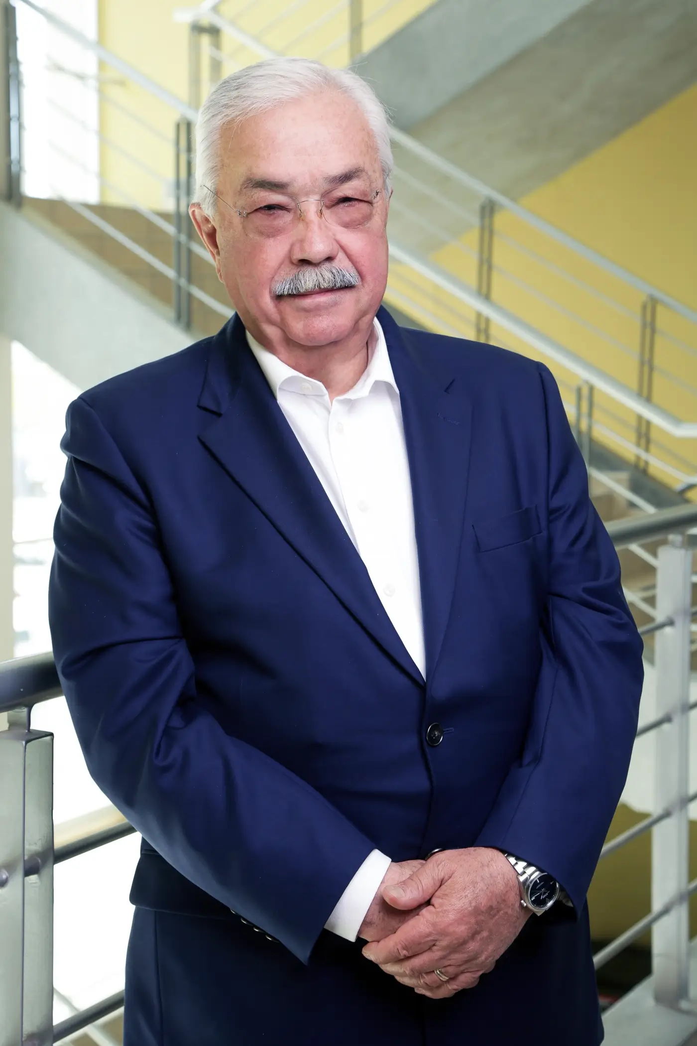 Mr. Tonella, member of the Tetakawi Board of Directors, in a navy suit beside a stairwell railing | Tetakawi