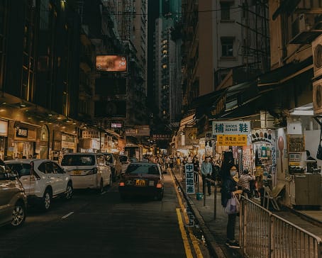 Busy city street at night with shops and Chinese signage, representing Asian manufacturing alternatives to Mexico | Tetakawi