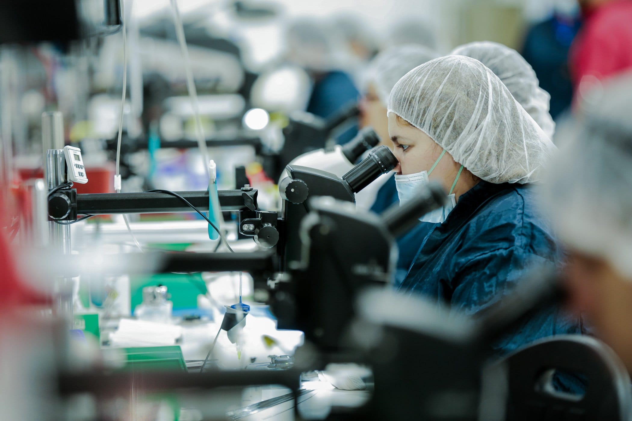 Technician performing precision microscope assembly of medical device components in a Mexico cleanroom | Tetakawi