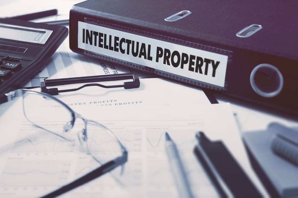 Office folder with inscription intellectual property on office desktop with office supplies. business concept on blured backg