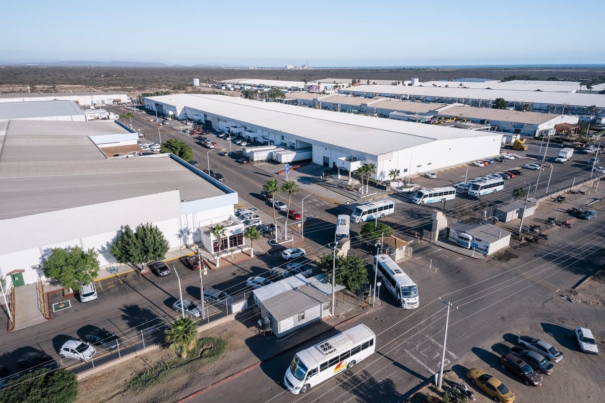 Aerial view of a Tetakawi Manufacturing Campus with employee shuttle buses and shared facilities in Mexico | Tetakawi