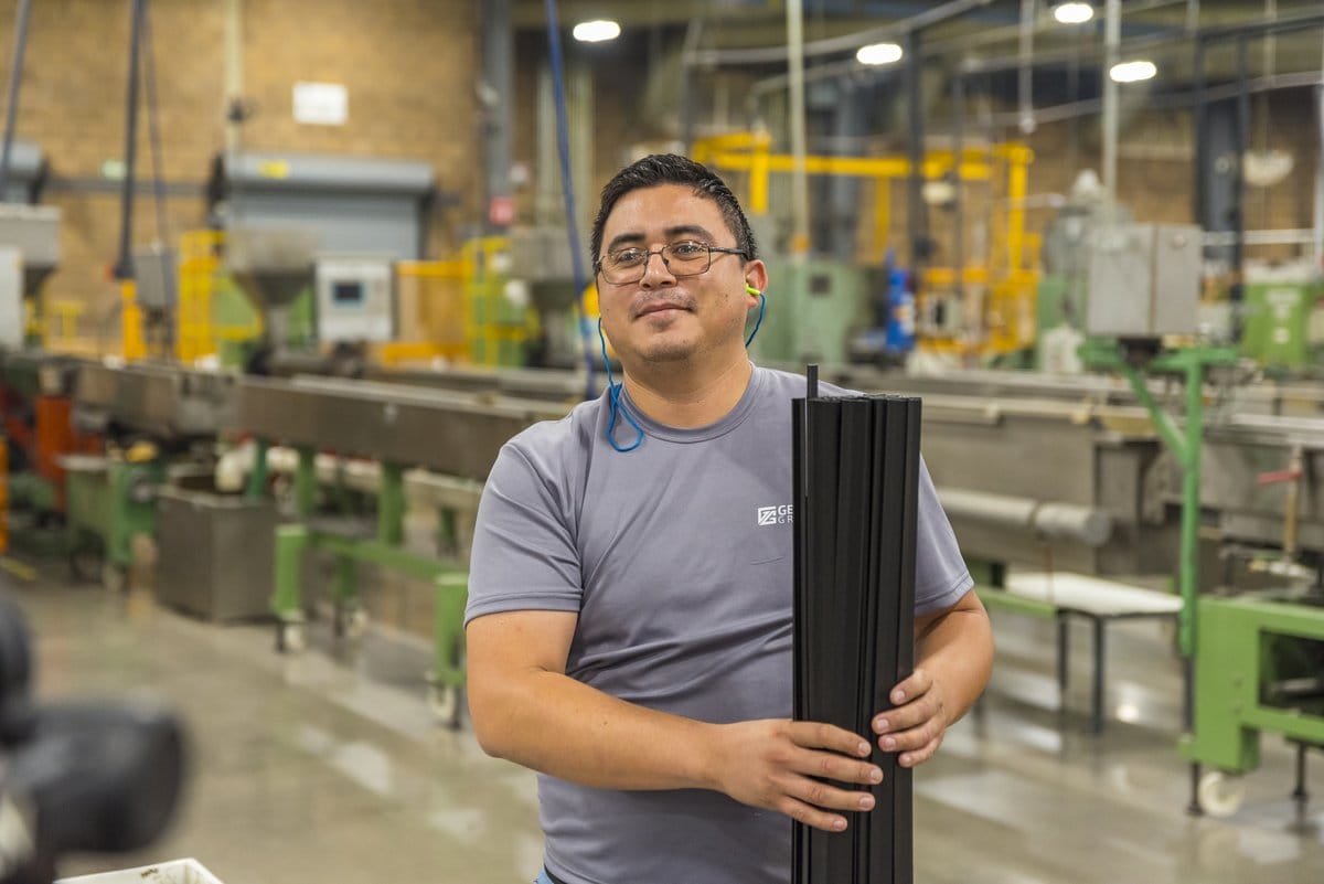 A Tetakawi team member holds a finished component on a Manufacturing Campus production floor in Mexico | Tetakawi