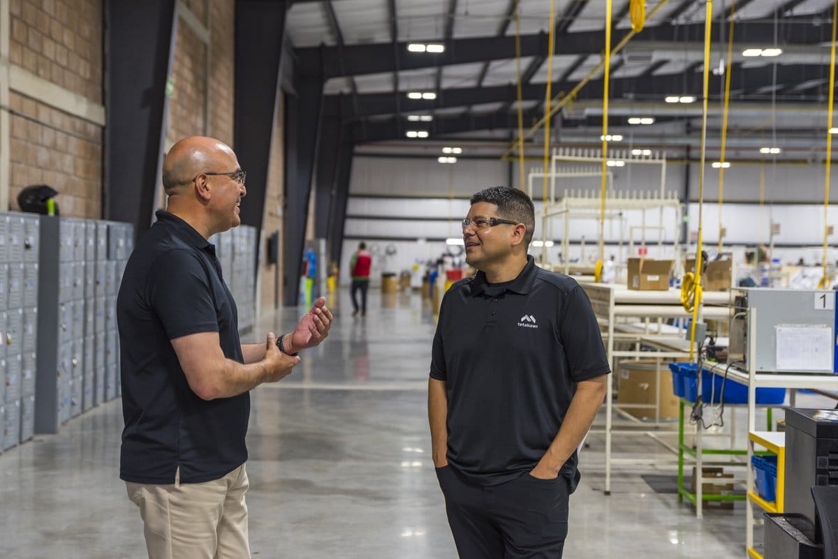 Tetakawi team members discuss operations on a Manufacturing Campus production floor in Mexico | Tetakawi