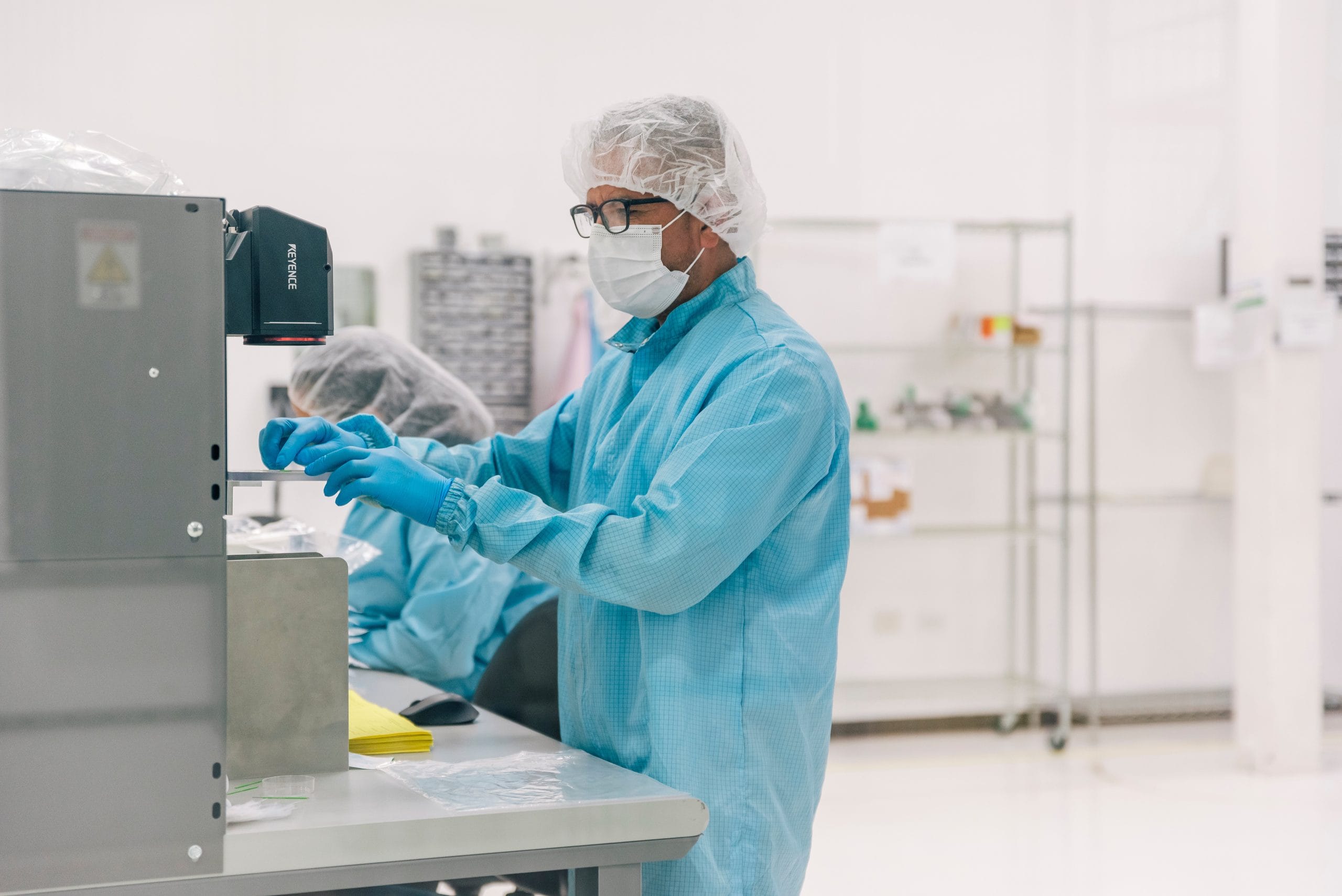 Technician in cleanroom PPE preparing medical device components for COFEPRIS registration in Mexico | Tetakawi