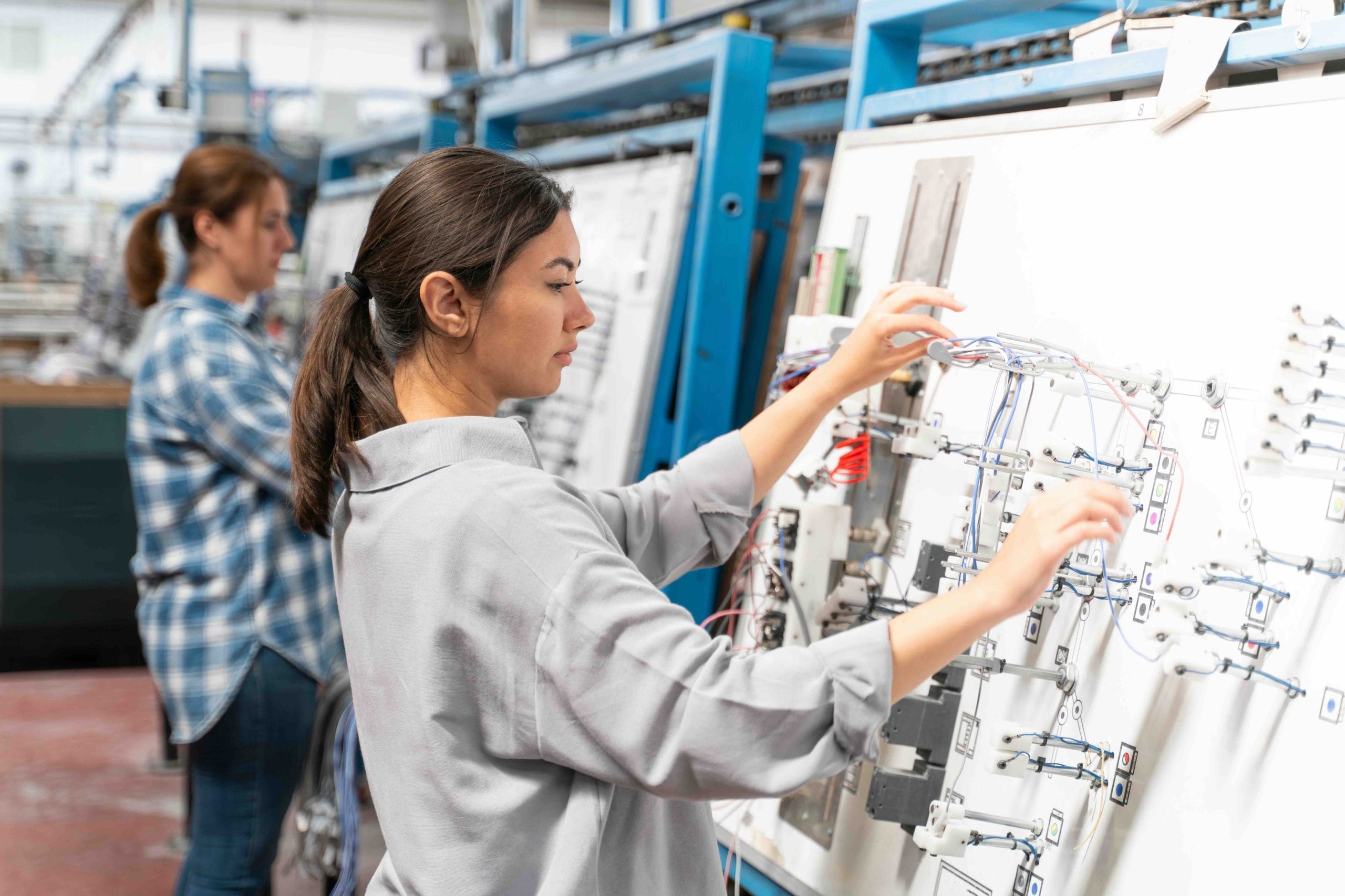 Technician routing wires on an electrical harness test board, appliance manufacturing in Mexico | Tetakawi