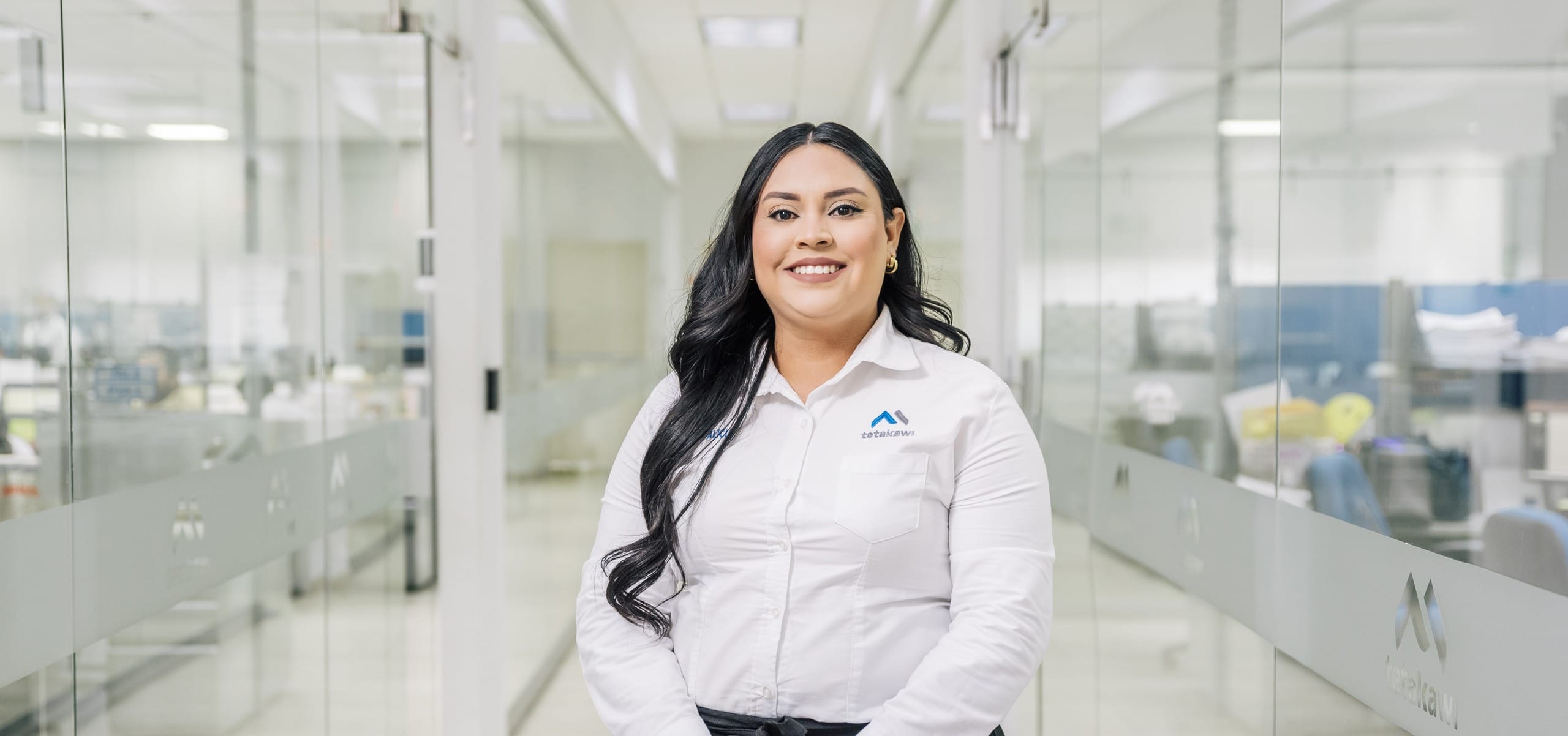 Tetakawi team member walking a manufacturing campus corridor, part of the regulatory machinery run daily in Mexico