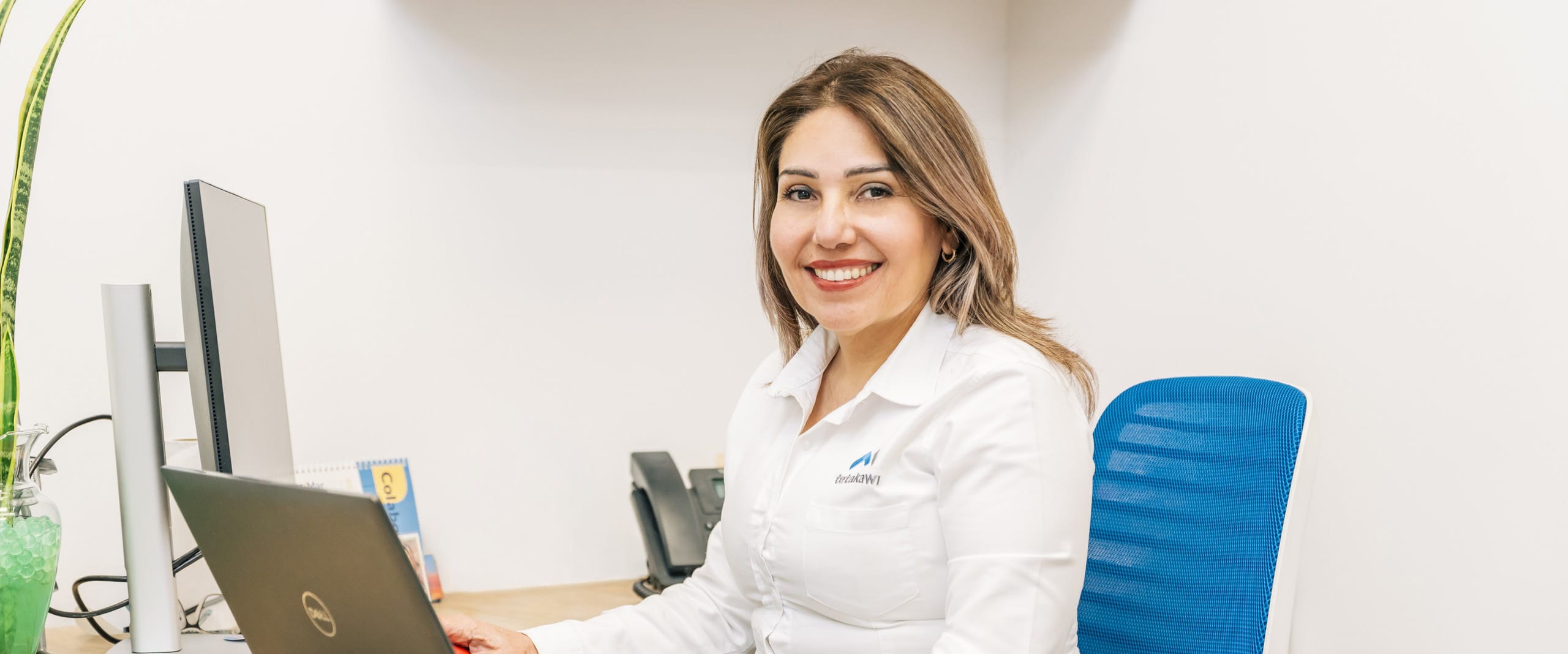 Tetakawi team member smiling at her desk in Mexico, representing human capital management support