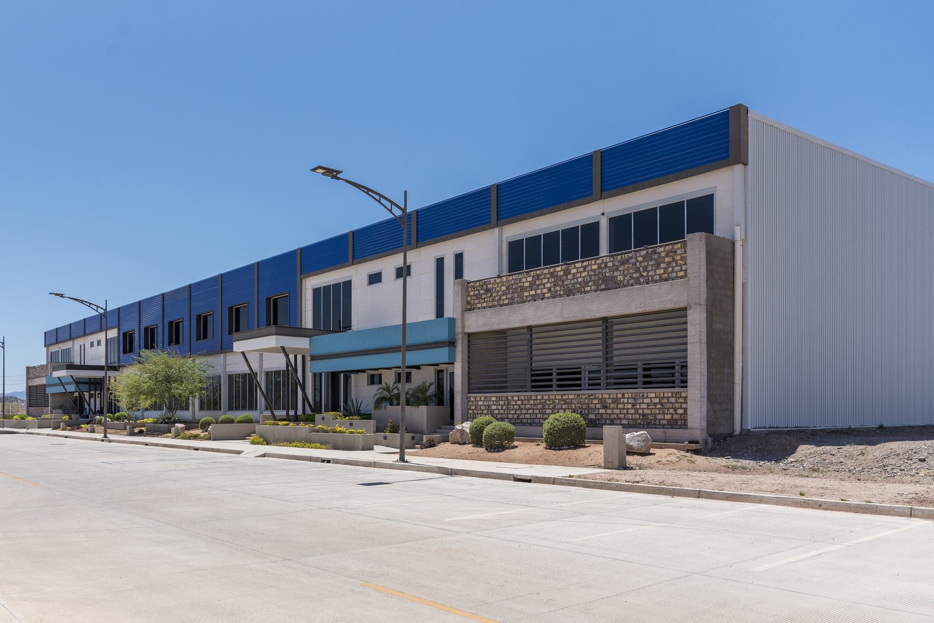 Two-story industrial space building with blue facade panels at Tetakawi's Rio Sonora Campus in Hermosillo, Sonora | Tetakawi