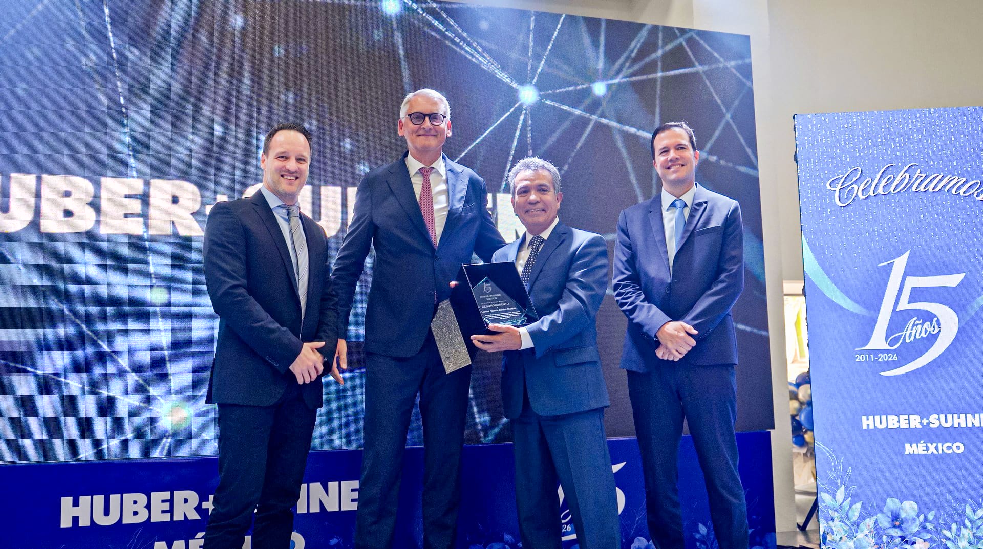 HUBER+SUHNER Mexico executives presenting a 15th anniversary recognition plaque to plant manager Carlos Rivera | Tetakawi