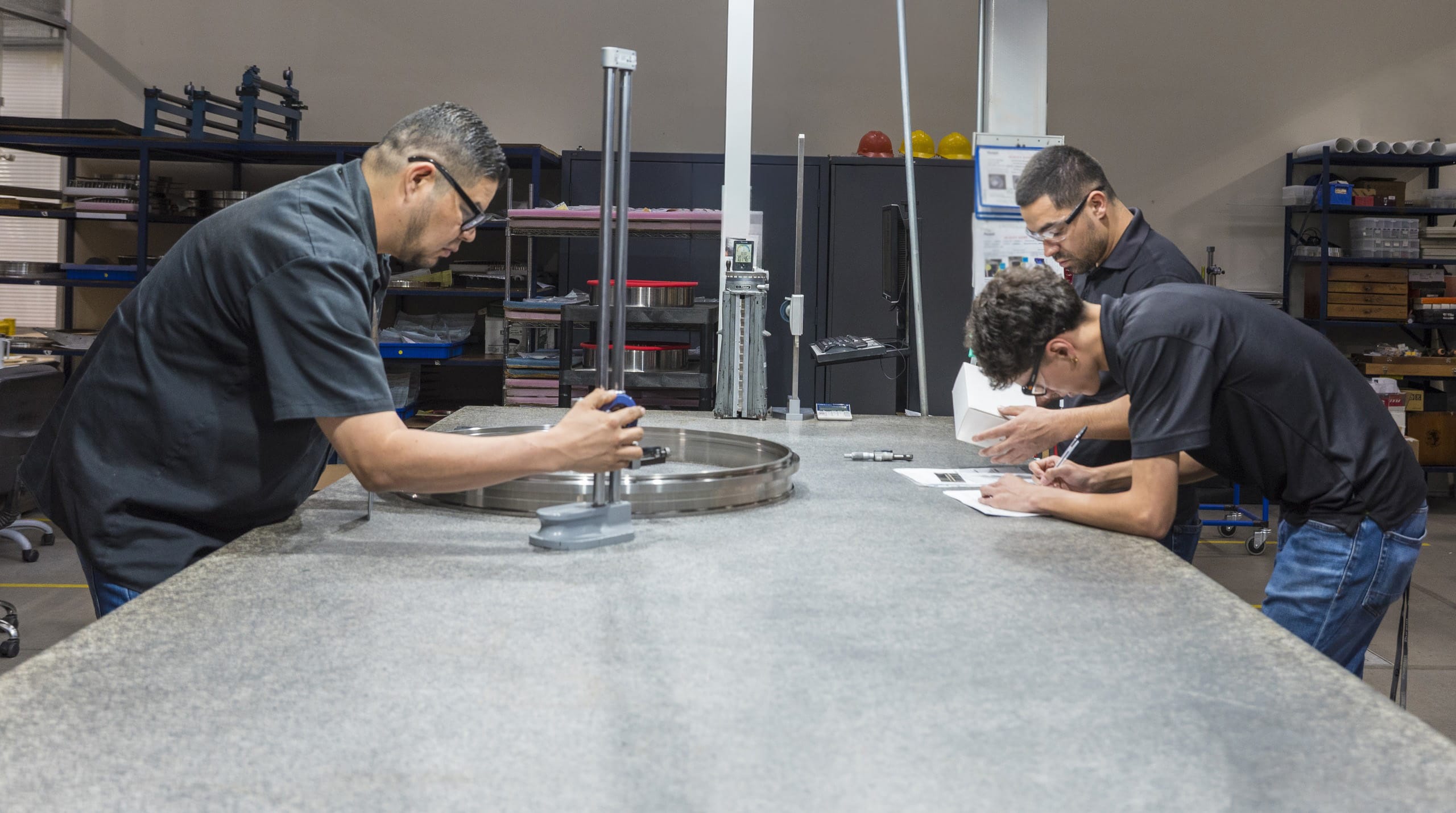 Pursuit Aerospace team members performing precision inspection of an engine component at Tetakawi's Roca Fuerte Campus in Guaymas, Mexico