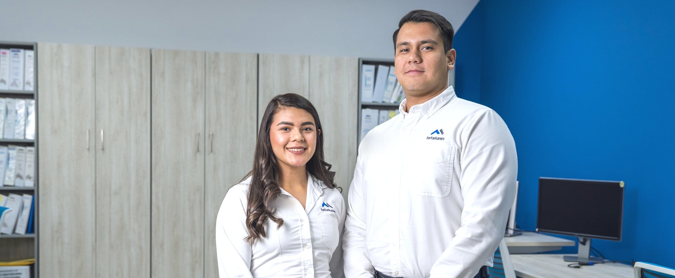 Tetakawi team members standing together in a modern office, ready to support manufacturers starting operations in Mexico | Tetakawi