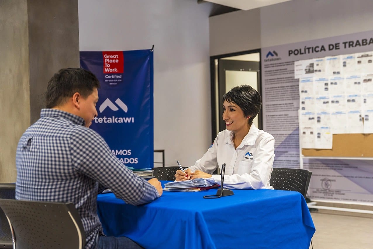 Tetakawi recruiter in a white company shirt interviewing a job candidate at a hiring table in Mexico | Tetakawi